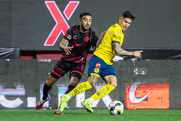 Alan Cervantes of America fights for the ball with Jaime Alvarez of Tijuana during the play-in match between Tijuana and America as part of the Tor...